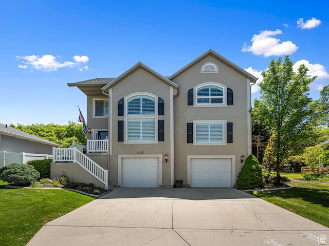 1152 E Gavin Cir, Draper, UT 84020 - view of front of house with concrete driveway, an attached garage, a front yard, stucco siding, and stairway