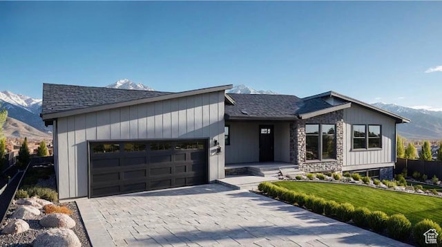 7119 S Rocky Trl Unit 102, West Jordan, UT 84084 - view of front of house featuring a mountain view, an attached garage, a front lawn, decorative driveway, and roof with shingles