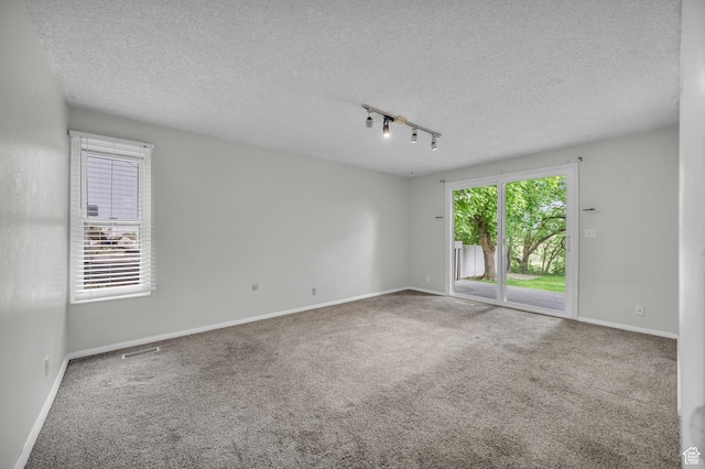 1054 E Lamplighter Dr, River Heights, UT 84321 - carpeted empty room with track lighting, a textured ceiling, and baseboards
