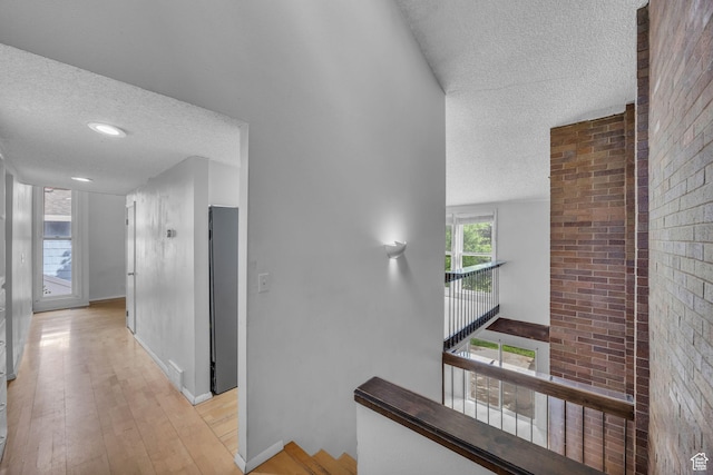 1054 E Lamplighter Dr, River Heights, UT 84321 - hall with a textured ceiling, light wood-style flooring, and baseboards