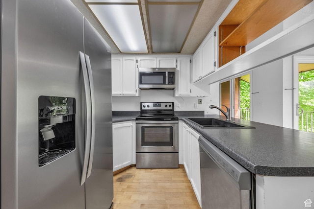 1054 E Lamplighter Dr, River Heights, UT 84321 - kitchen featuring appliances with stainless steel finishes, a sink, dark countertops, light wood-type flooring, and white cabinetry