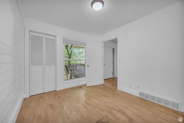 1054 E Lamplighter Dr, River Heights, UT 84321 - unfurnished bedroom with a textured ceiling, light wood-style flooring, a closet, and baseboards
