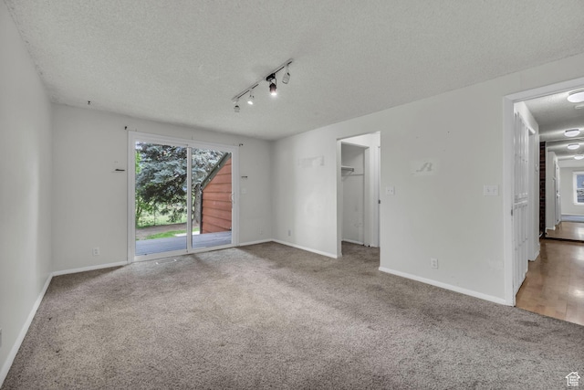 1054 E Lamplighter Dr, River Heights, UT 84321 - unfurnished bedroom with carpet, a textured ceiling, access to exterior, track lighting, and baseboards