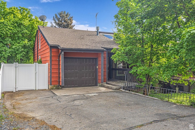 1054 E Lamplighter Dr, River Heights, UT 84321 - view of front of house with a shingled roof, asphalt driveway, a gate, and an attached garage