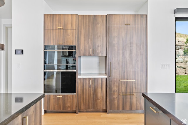 1620 W Brevia Ct Unit 25, Lehi, UT 84043 - kitchen featuring modern cabinets, light wood finished floors, dark countertops, and brown cabinetry