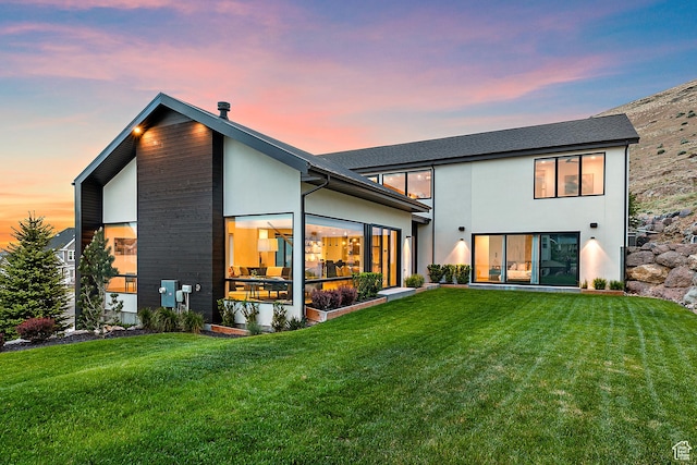 1620 W Brevia Ct Unit 25, Lehi, UT 84043 - back of property at dusk featuring a lawn, stucco siding, and a sunroom