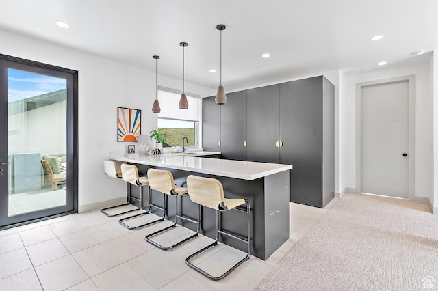 1620 W Brevia Ct Unit 25, Lehi, UT 84043 - kitchen featuring a breakfast bar area, light countertops, a peninsula, decorative light fixtures, and recessed lighting