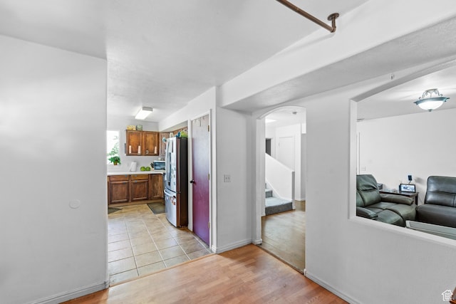 444 E 670 N, Tooele, UT 84074 - kitchen featuring freestanding refrigerator, arched walkways, light wood-type flooring, light countertops, and baseboards