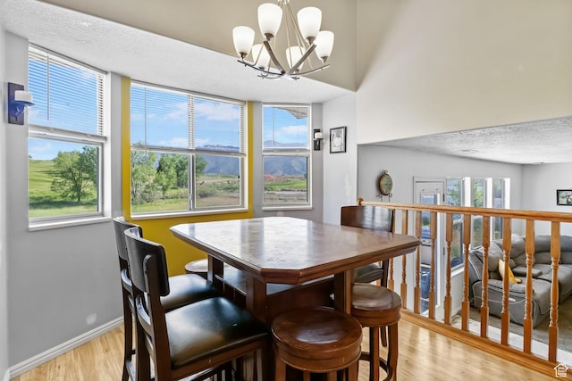 1367 E 3125 N, Layton, UT 84040 - dining space with light wood finished floors, a chandelier, baseboards, and a textured ceiling