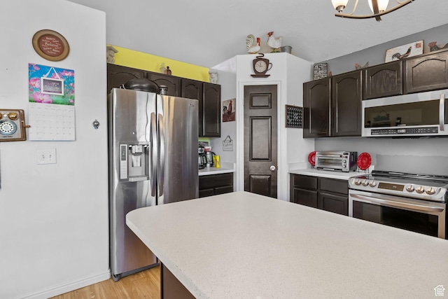 1367 E 3125 N, Layton, UT 84040 - kitchen featuring appliances with stainless steel finishes, light countertops, light wood-type flooring, dark brown cabinets, and baseboards