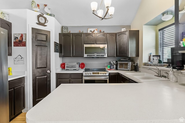 1367 E 3125 N, Layton, UT 84040 - kitchen featuring appliances with stainless steel finishes, a sink, light countertops, dark brown cabinetry, and a peninsula