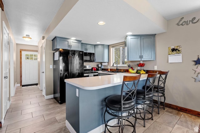 10246 E Lake Pines Dr Unit 1020, Heber City, UT 84032 - kitchen with black appliances, a peninsula, a sink, baseboards, and a breakfast bar area