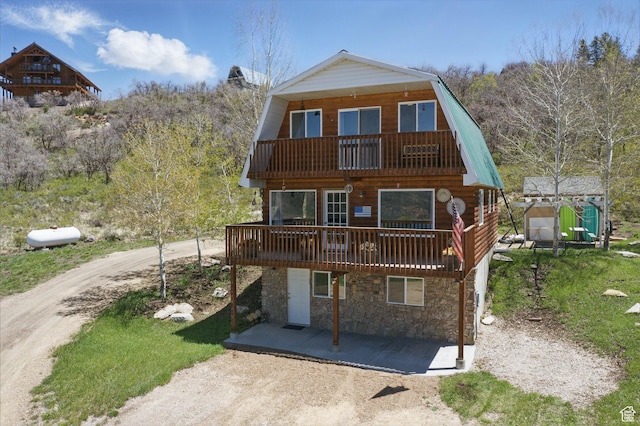 10246 E Lake Pines Dr Unit 1020, Heber City, UT 84032 - view of front of home with a gambrel roof, a balcony, stone siding, and a deck