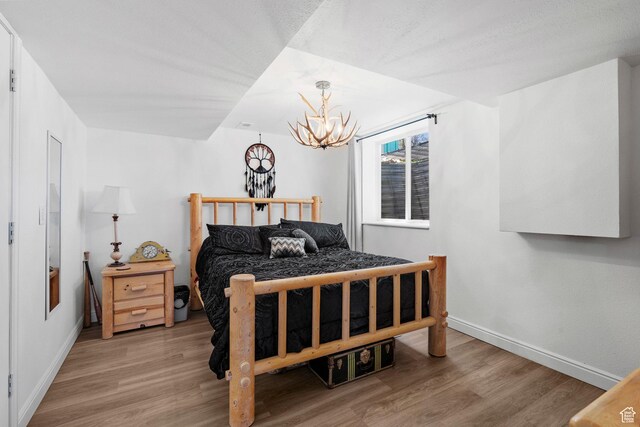 10246 E Lake Pines Dr Unit 1020, Heber City, UT 84032 - bedroom with wood finished floors, a chandelier, and baseboards