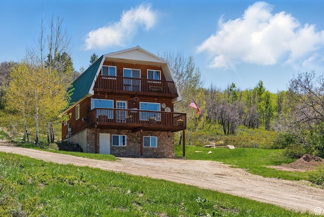 10246 E Lake Pines Dr Unit 1020, Heber City, UT 84032 - back of property with a gambrel roof, stone siding, a balcony, metal roof, and a wooden deck