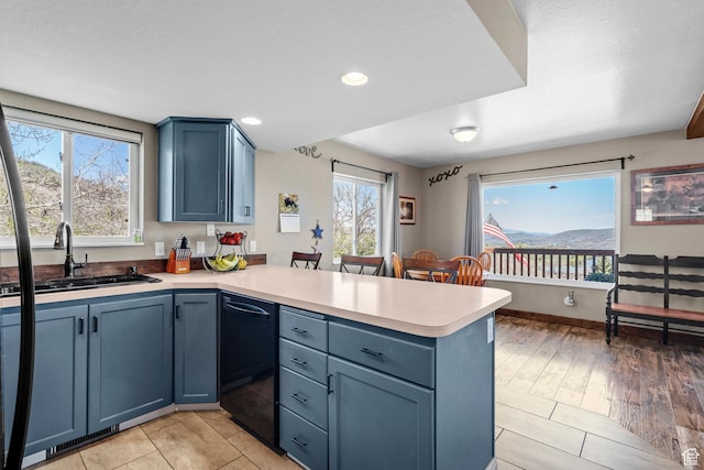 10246 E Lake Pines Dr Unit 1020, Heber City, UT 84032 - kitchen with a peninsula, dishwasher, a sink, blue cabinets, and light countertops