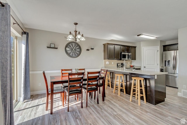 3864 E Cascade Rd, Eagle Mountain, UT 84005 - dining space featuring light wood-type flooring, a chandelier, and baseboards