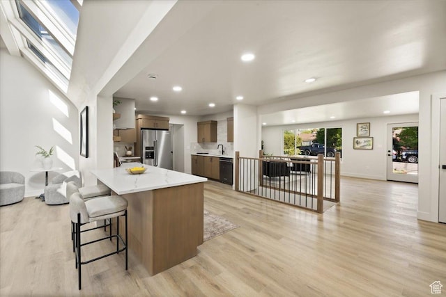 2559 E Evening Star Dr, Holladay, UT 84124 - kitchen featuring stainless steel refrigerator with ice dispenser, dishwasher, open floor plan, recessed lighting, and light wood-style flooring
