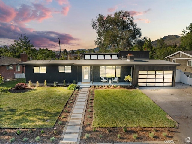 2559 E Evening Star Dr, Holladay, UT 84124 - mid-century modern home featuring an attached garage, driveway, and a chimney