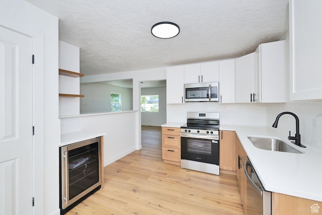 4673 W 5255 S, Kearns, UT 84118 - kitchen featuring stainless steel appliances, beverage cooler, a sink, light wood-style floors, and light countertops