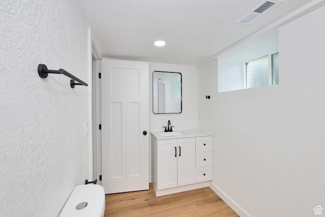 4673 W 5255 S, Kearns, UT 84118 - bathroom featuring vanity, wood finished floors, toilet, a textured wall, and recessed lighting
