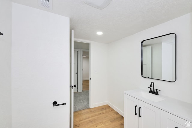 4673 W 5255 S, Kearns, UT 84118 - bathroom with wood finished floors, vanity, baseboards, recessed lighting, and a textured ceiling