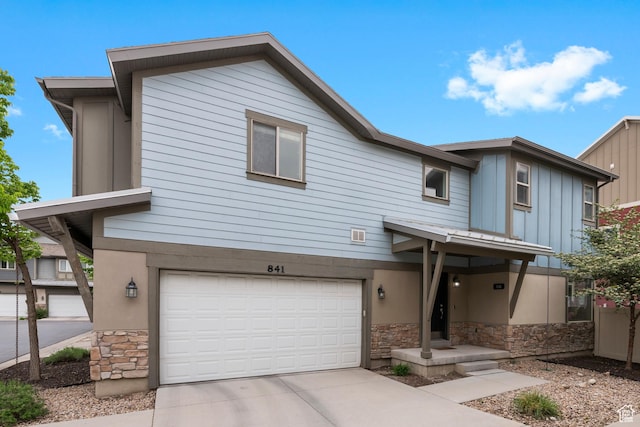 841 W Cannara Way S, Midvale, UT 84047 - view of property with stone siding, driveway, a garage, and board and batten siding