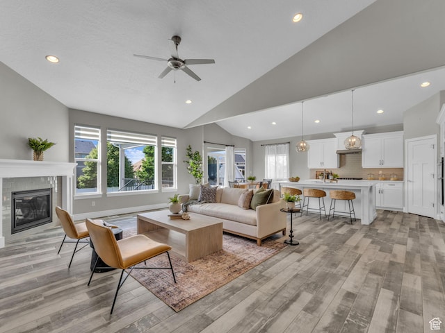 1949 W Shadow Way, Kaysville, UT 84037 - living room featuring light wood-style floors, ceiling fan, a glass covered fireplace, recessed lighting, and high vaulted ceiling