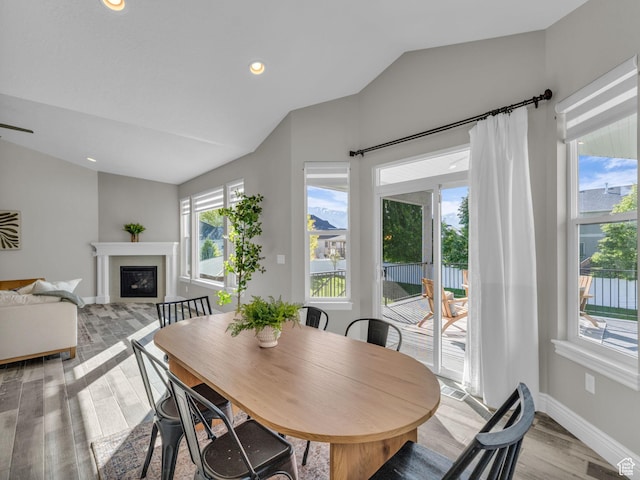 1949 W Shadow Way, Kaysville, UT 84037 - dining space with lofted ceiling, light wood-style floors, a glass covered fireplace, baseboards, and recessed lighting