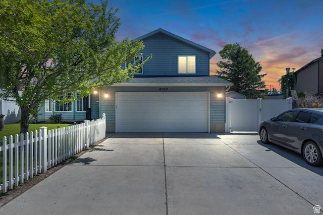6169 Longmore Dr, Salt Lake City, UT 84118 - view of front facade featuring driveway, an attached garage, and a gate