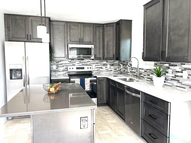 376 E 770 N, Tooele, UT 84074 - kitchen featuring stainless steel appliances, a sink, decorative backsplash, a kitchen island, and decorative light fixtures