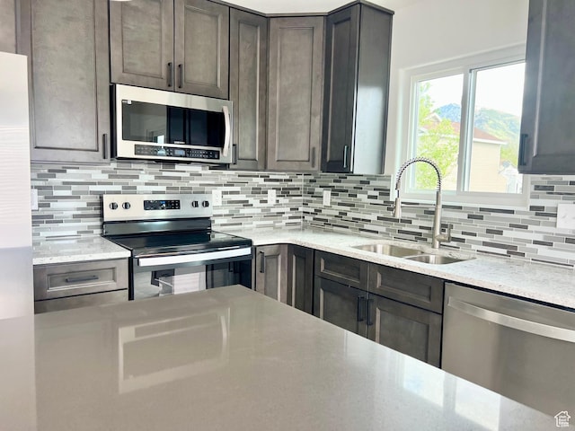 376 E 770 N, Tooele, UT 84074 - kitchen with stainless steel appliances, a sink, backsplash, and light stone countertops