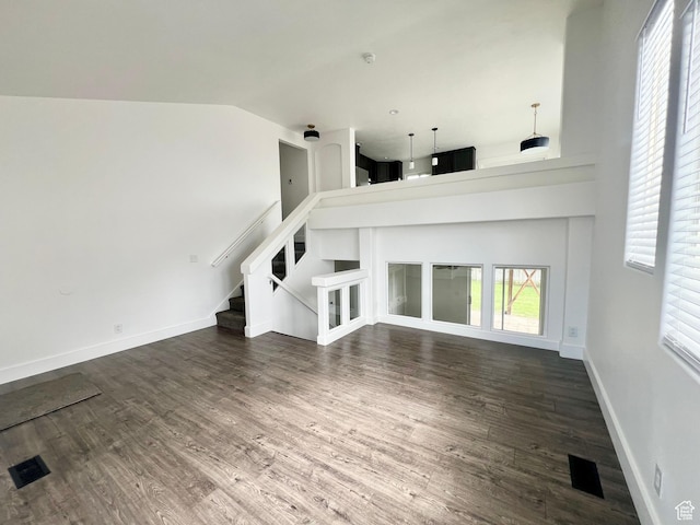 376 E 770 N, Tooele, UT 84074 - unfurnished living room with dark wood-type flooring, stairs, baseboards, and high vaulted ceiling