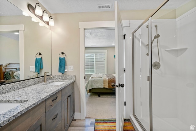 641 E Green Springs Way Unit 324, South Weber, UT 84405 - ensuite bathroom featuring double vanity, a stall shower, a textured ceiling, wood finished floors, and baseboards