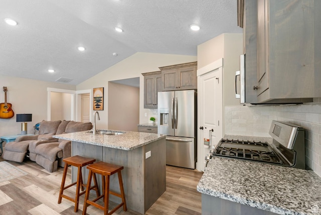 641 E Green Springs Way Unit 324, South Weber, UT 84405 - kitchen featuring stainless steel appliances, a sink, open floor plan, light wood-style floors, and lofted ceiling