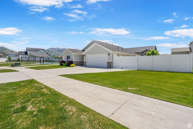 641 E Green Springs Way Unit 324, South Weber, UT 84405 - view of front facade featuring stone siding, concrete driveway, a garage, a gate, and a mountain view