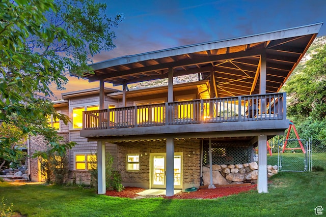3286 N Piute Dr, Provo, UT 84604 - back of property at dusk featuring a yard, a wooden deck, brick siding, and a gate