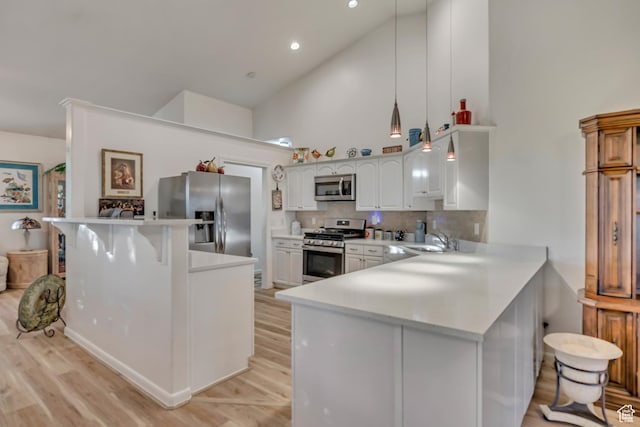 3286 N Piute Dr, Provo, UT 84604 - kitchen featuring stainless steel appliances, a peninsula, a sink, light wood-style floors, and light countertops