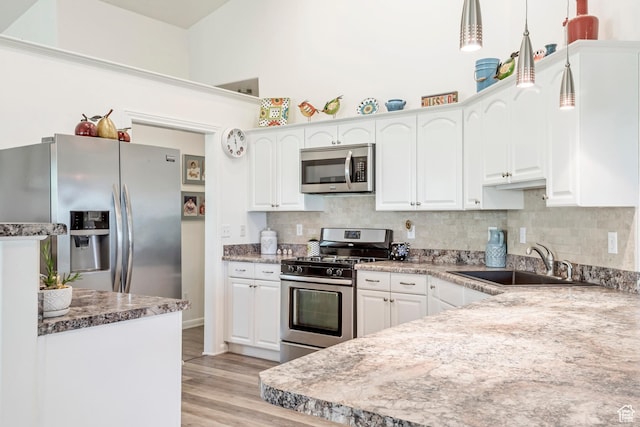 3286 N Piute Dr, Provo, UT 84604 - kitchen featuring stainless steel appliances, a sink, white cabinets, and a towering ceiling