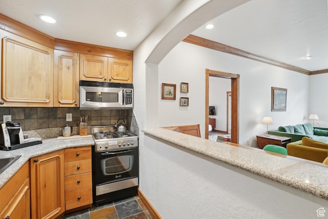 840 Bigler Ln Unit 2021, Midway, UT 84049 - kitchen featuring appliances with stainless steel finishes, arched walkways, light countertops, tasteful backsplash, and crown molding