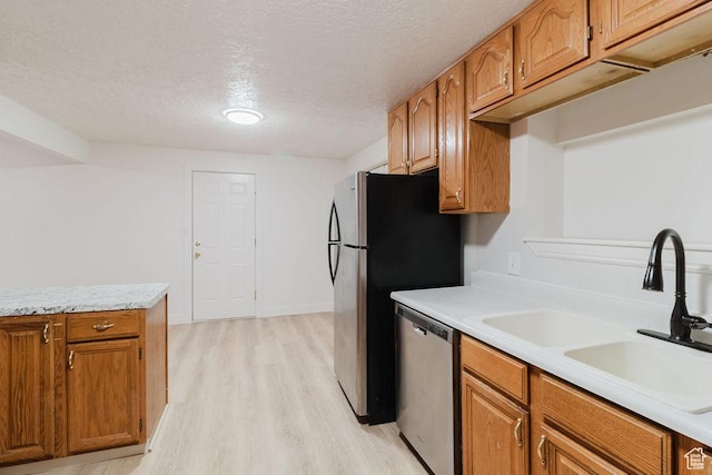 171 E 200 N, Orem, UT 84057 - kitchen featuring appliances with stainless steel finishes, a sink, light wood-type flooring, light countertops, and a textured ceiling