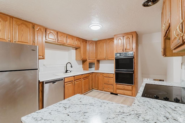 171 E 200 N, Orem, UT 84057 - kitchen with black appliances, a textured ceiling, light wood-style floors, light countertops, and a sink