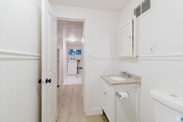171 E 200 N, Orem, UT 84057 - half bathroom featuring vanity, wood finished floors, washer / dryer, wainscoting, and toilet