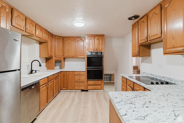171 E 200 N, Orem, UT 84057 - kitchen featuring black appliances, light wood-style flooring, a sink, a textured ceiling, and light countertops