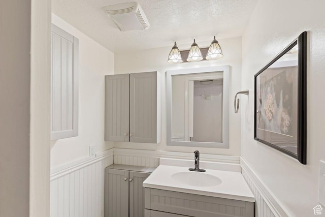 1162 S 885 E, Ogden, UT 84404 - bathroom with vanity, a textured ceiling, and wainscoting