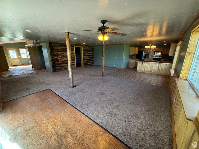 149 Thomas Fork Ln, Geneva, ID 83238 - unfurnished living room with a chandelier, a textured ceiling, carpet, a ceiling fan, and wood finished floors
