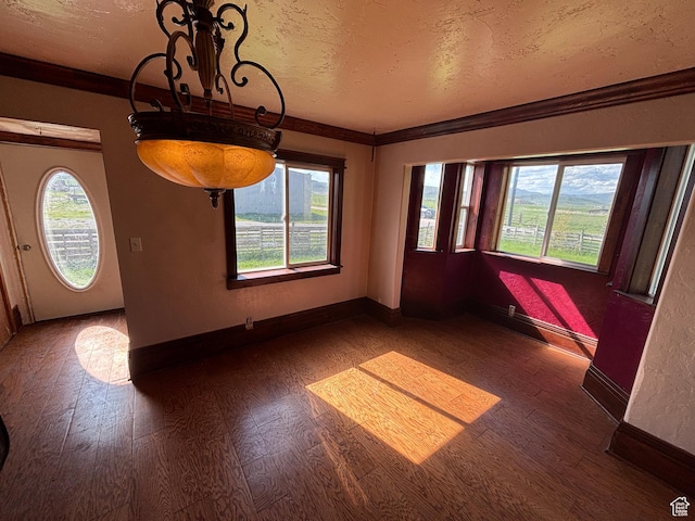 149 Thomas Fork Ln, Geneva, ID 83238 - unfurnished dining area featuring wood finished floors, plenty of natural light, baseboards, and a textured ceiling