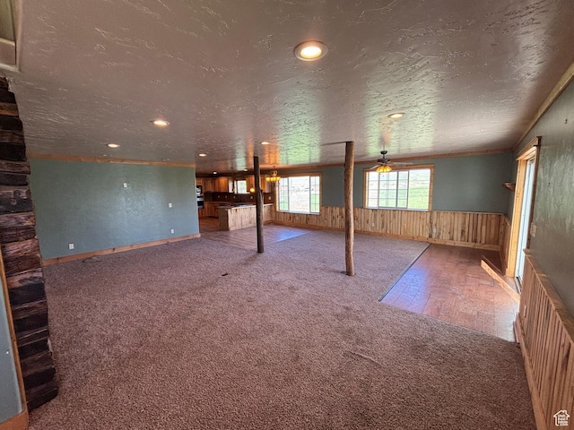 149 Thomas Fork Ln, Geneva, ID 83238 - unfurnished living room with carpet, ceiling fan, wainscoting, recessed lighting, and wood walls