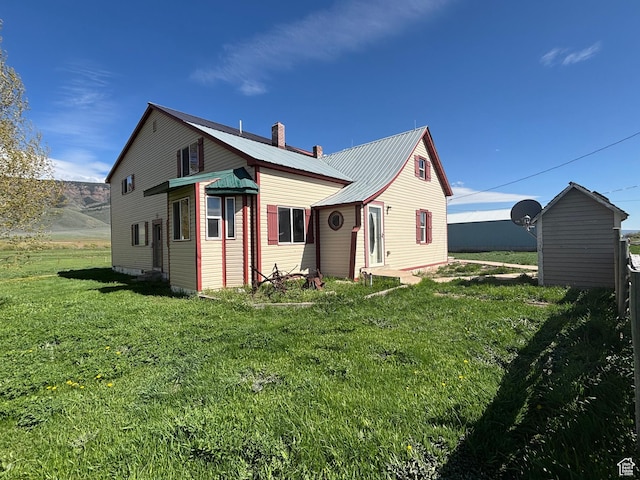 149 Thomas Fork Ln, Geneva, ID 83238 - rear view of property featuring a yard, metal roof, and a chimney