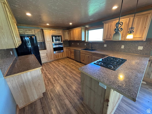 149 Thomas Fork Ln, Geneva, ID 83238 - kitchen with black appliances, a sink, a peninsula, dark wood-style flooring, and backsplash